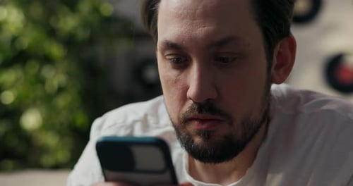 Man Reacts to Content on Smartphone