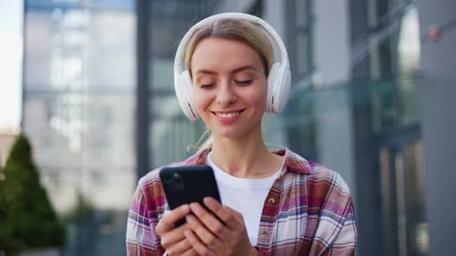 Adorable Woman in White Headphones Enjoys Music Dancing Walking Outdoors