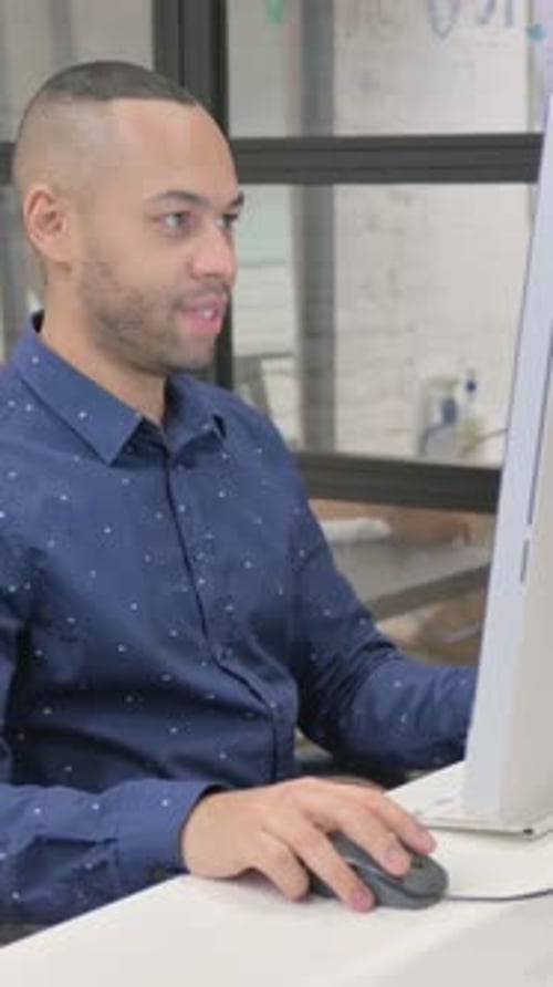Excited Hispanic Businessman Celebrating Success on Desktop in Office, vertical video
