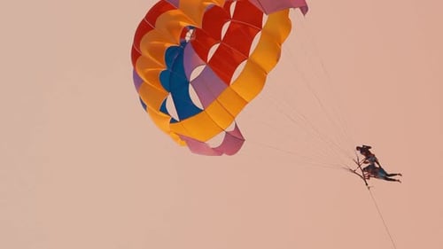 Parasailer fliegen auf buntem Fallschirm