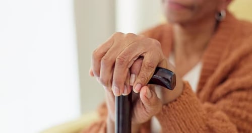 Hands, walking stick and senior woman with a disability, dementia or Alzheimer in a nursing home