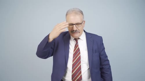 Confused Businessman Gesturing Against Plain Background