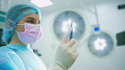 nurse or surgeon in sterile glove holding scalp surgical instruments in hand during surgery close-up