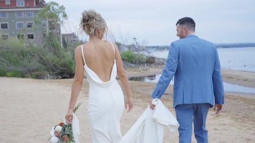Newlyweds Walking on the Beach After Wedding Ceremony