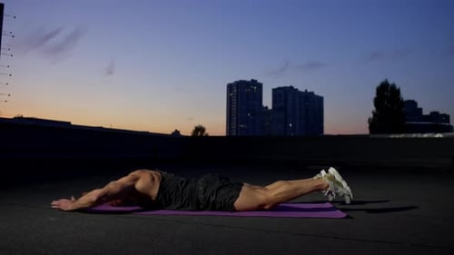 Muscular Man Doing Push-ups on City Rooftop
