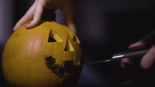 Mit einem Messer den Mund in einen Kürbis schnitzen - Nahaufnahme