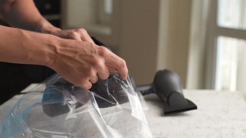 Man Packing Shoes in Plastic Bag Indoors