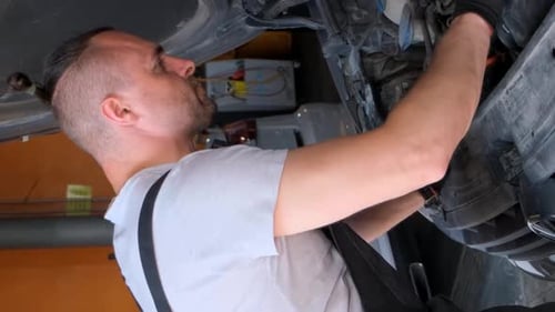 Mechanic Working on Car Engine in Garage Workshop Concept of Car Service and Car Maintenance