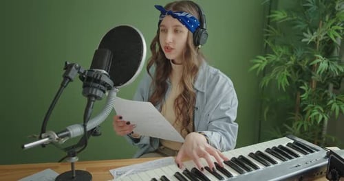 Young Woman Singing and Playing Keyboard in Studio