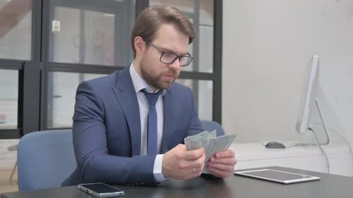 Verdienender Geschäftsmann, der bei der Arbeit Geld zählt