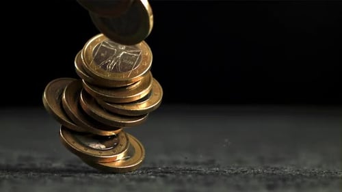 Las monedas de euro cayendo en la superficie se filman en cámara lenta a 1000 fps