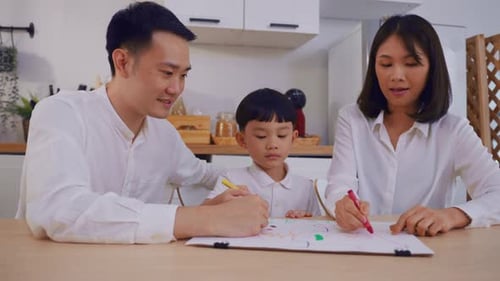 Family Drawing Together at Kitchen Table