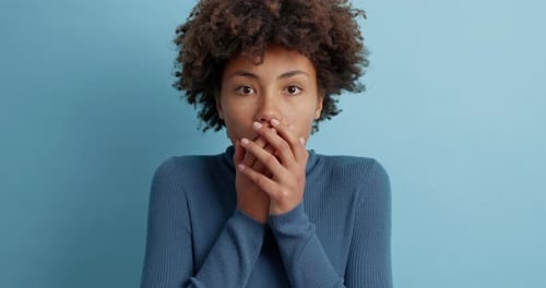 Surprised woman with curly hair, wide eyed