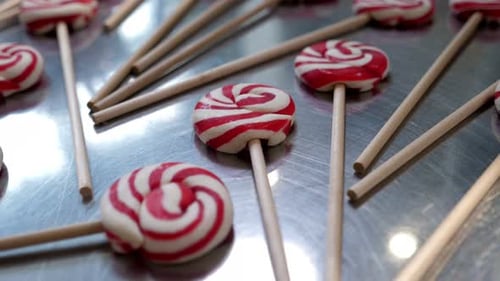 Closeup of Different Red and White Lollipops in a Candy Store on a Metal Table