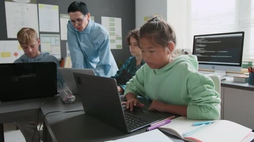 Diligent Asian Girl Working on her Laptop During Programming Lesson in School