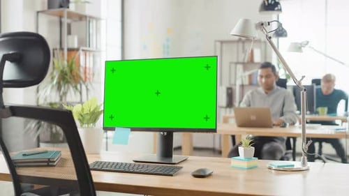 Mock-up Screen Desktop Computer Standing on the Desk in the Modern Creative Office. In the Backgrou