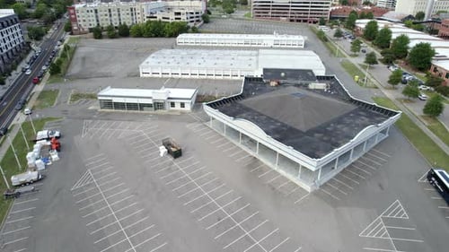 Aerial Drone over empty parking lot, construction site, building to be demolished.