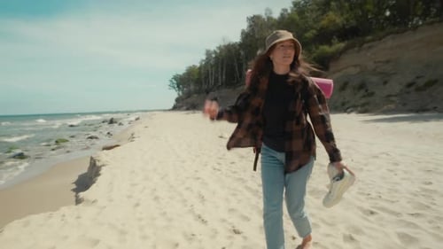 Woman traveler walks along a wild beach