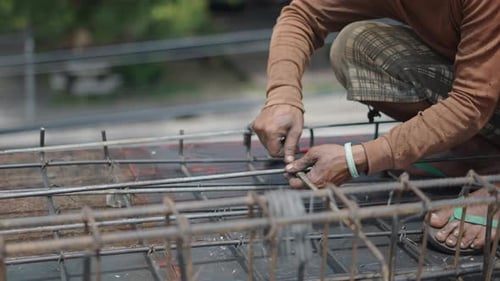 Unrecognizable Man In Building Site Is Using Pincers In Fixing Steel Reinforcement