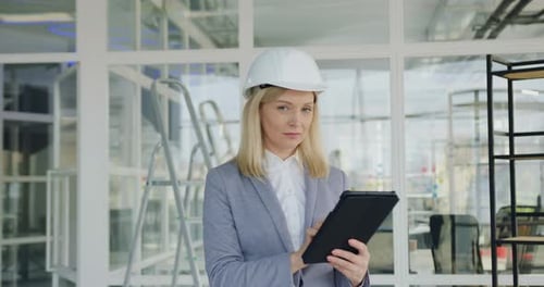 Woman Wearing Hardhat Uses Tablet in Office