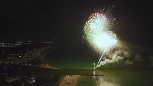 Vista aérea de fogos de artifício brilhantes explodindo com luzes coloridas sobre a costa do mar no Dia da Independência dos EUA