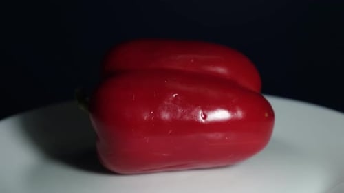 Vibrant Red Bell Pepper Rotating in Dark Studio