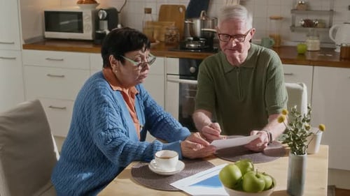 Senior Couple Reviews Documents in Bright Kitchen