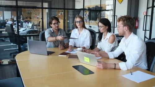 Modern young business people in formal clothes working in the office by using laptops and documents