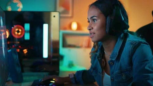 Girl Gaming at Computer With Headphones in Room