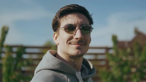 Cara bonito e alegre com óculos de sol curtindo o sol e o ar fresco