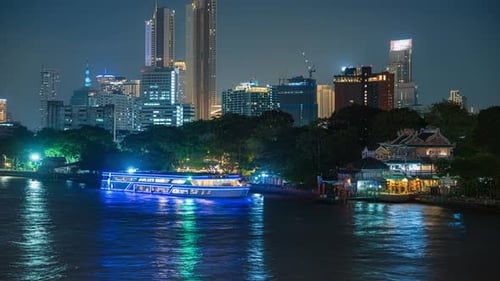 Panning time-lapse of ferries on Chao Phraya river in Bangkok, night in Thailand