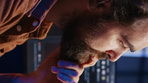 Software Engineer Puzzled in Front of Computer Screen While Writing Complex Code