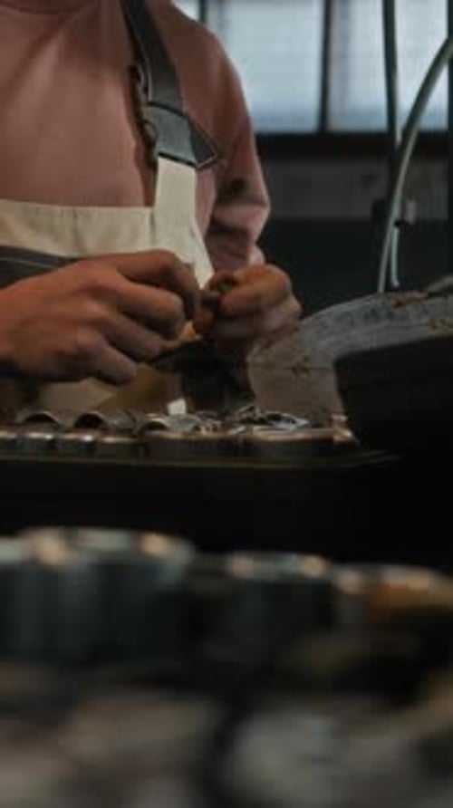 Vertical of Workman Using Toolkit and Wiping Hands in Garage