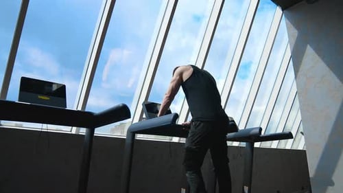 Fitness man running on treadmill. Young man running on the treadmill in the fitness studio
