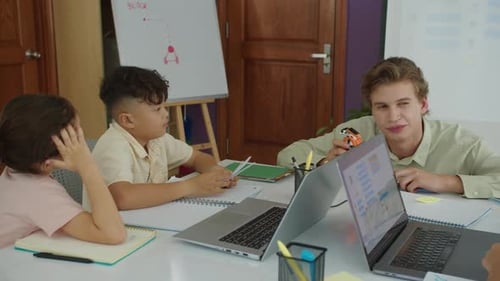 Cheerful Male Teacher Explaining New Topic at Robot Engineering Class to Kids