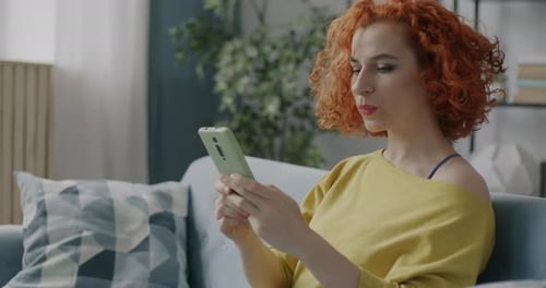 Cheerful Young Lady Using Smartphone Surfing Internet Enjoying Online Communication at Home