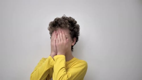 Smiling Young Person Covering Face Indoors