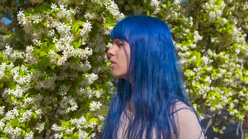 Girl with Blue Hair Sneezes by Flowering Tree