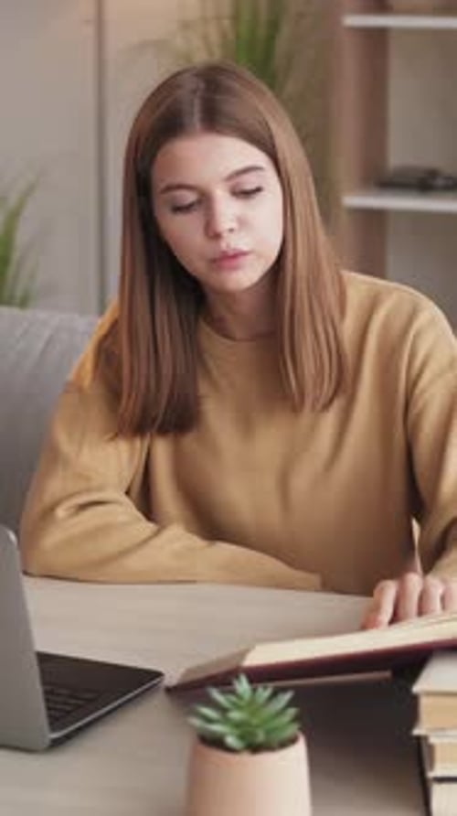 Girl Studying with Laptop and Book at Home
