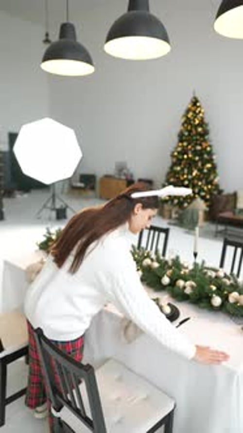 Young Woman Setting New Year's Table at Living Room