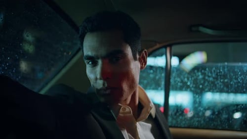 Serious Man Riding in Car at Night