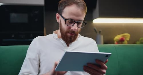 Man Using Tablet on Couch at Home
