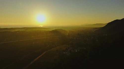 Die Sonne beleuchtet das Gebirgstal während der Goldenen Stunde