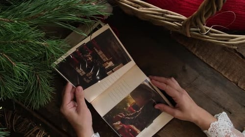 Las manos pasan las páginas de las fotos navideñas impresas de un álbum familiar