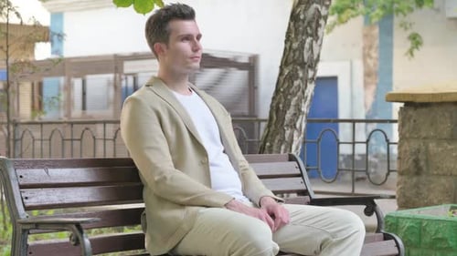 Young Man Relaxing on a Park Bench