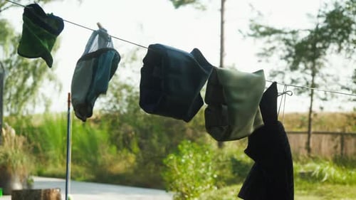Equipo para actividades al aire libre secándose en un tendedero en un paisaje sereno. Perfecto para documentales sobre la naturaleza o
para acampar