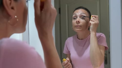 The female paints her eyelashes.