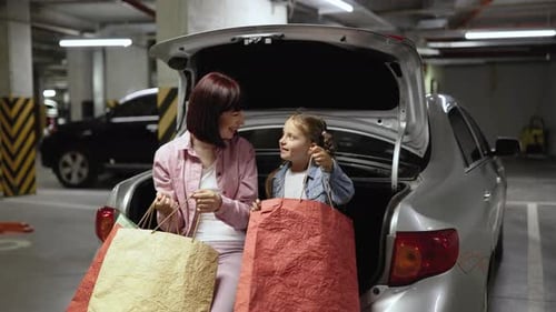 Woman and Child with Shopping Bags in Car Trunk