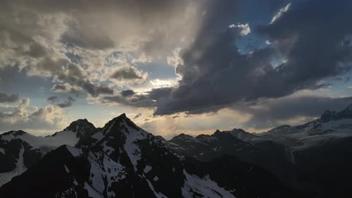 Rayon de soleil perçant le ciel nuageux au-dessus d'un paysage de montagne