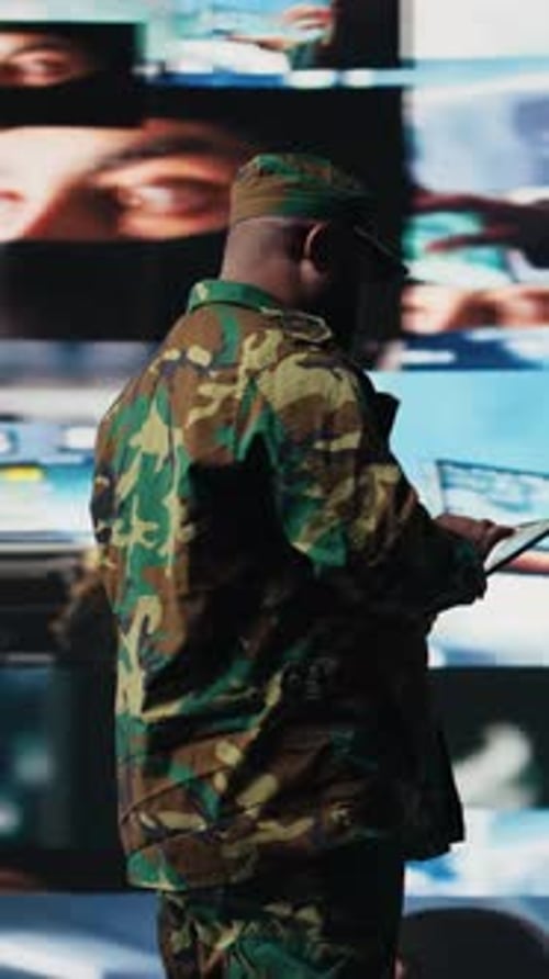 Man in Camouflage Using Tablet